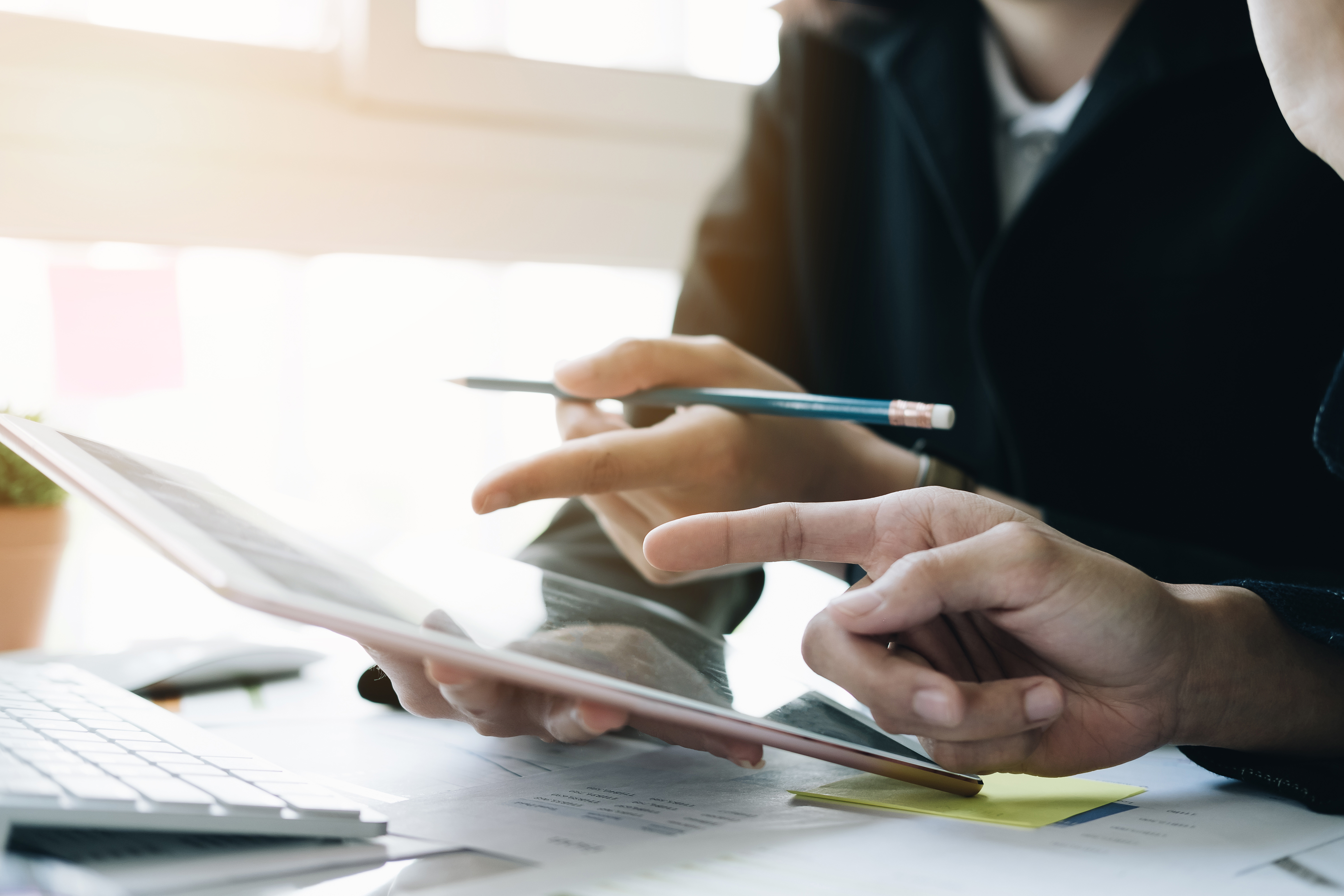 Colleagues reviewing documents on a tablet
