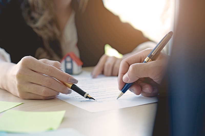 A man signing a document A man signing a document